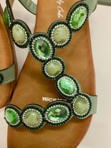 Close-up of beaded detail and cushioned sole on sage green sandals